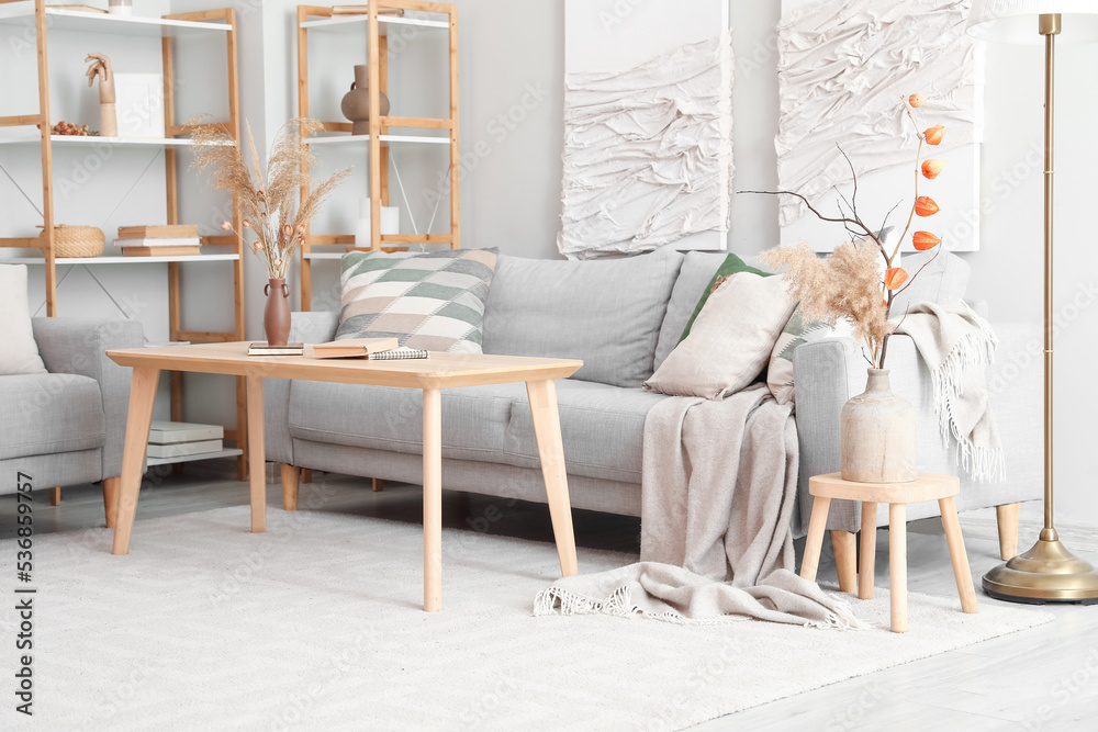 Interior of modern living room with sofas, table and 3D textile painting