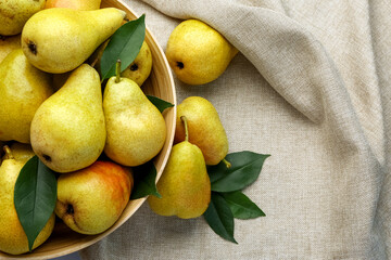 Wall Mural - Bowl with ripe pears on fabric background, closeup
