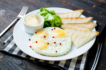 Wall Mural - Fried eggs with toasts on dark wooden table