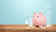 Piggy Bank On A Wooden Table With Blue Background. Saving Money And Invest Concept.