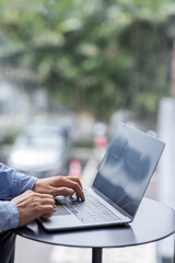 Young man working on he laptop with blank copy space screen for your advertising text message in office, Back view of business man hands busy using laptop at desk.