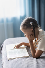 Wall Mural - Girl child reads a book in the room