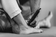 © Microgen - Laser Physical Therapy. Physical Therapist Treating Senior Woman's Foot