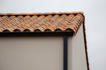 Wall Mural - Roof gutter black and downpipe on a new tiled roof home facade