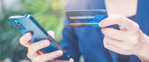 Wall Mural - Woman hand uses a cell phone and credit card to manage online shopping.