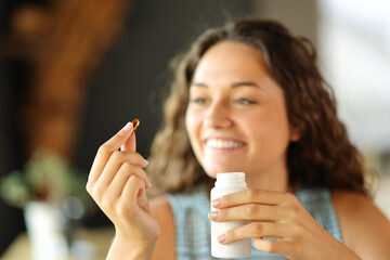 Happy woman ready to eat a vitamin pill