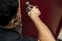 Man Repairing Lock Of Door