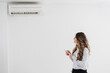 © Westend61 - Businesswoman switching on air conditioning in the office
