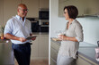 © Westend61 - Happy senior man holding tablet PC standing with woman in kitchen at home