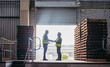 © Jacob Lund - Happy logistics partners shaking hands at a loading dock