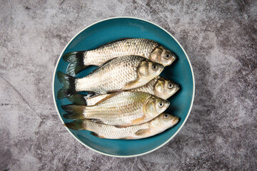 Wall Mural - Freshly freshwater fish Crucian carp in plate on table