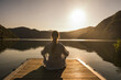 © Westend61 - Woman meditating on jetty over lake at vacation