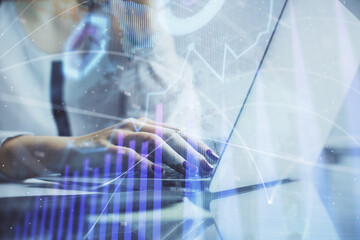 Wall Mural - Double exposure of woman hands typing on computer and financial graph hologram drawing. Stock market analysis concept.