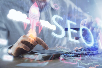 Poster - Double exposure of man hands holding a credit card and SEO drawing. Search engine optimization in Internet E-commerce concept.