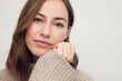 © Martin Villadsen - Portrait of young beautiful woman smiling and standing isolated on white background in a warm sweater. Young female girl with a perfect smile looking in camera.