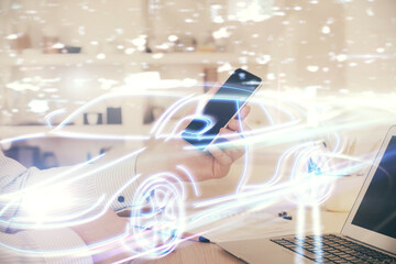 Poster - Double exposure of man's hands holding and using a digital device and automobile theme hologram drawing. Technology concept.