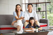 © aekkorn - Happy Asian family lifestyle enjoy watching TV in living room at home. Happy Asian family portrait with mother, father and daughter while writting note.
