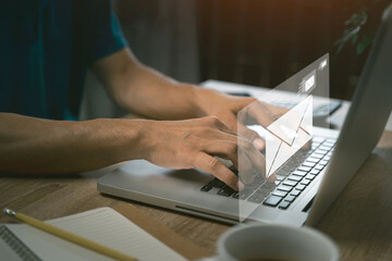 A Man online working internet network. Businessman hands using Laptop typing on keyboard and surfing the internet on office table with email icon, email marketing concept, send e-mail or news letter.