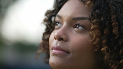 Meditative African American young woman closing eyes in contemplation. A black millennial girl opening eye smiling feeling grateful