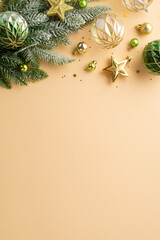 Christmas concept. Top view vertical photo of transparent gold and green baubles balls star ornaments pine branch in frost and confetti on isolated beige background with copyspace