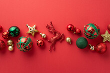 Christmas Decorations Concept. Top View Photo Of Reindeer Star Ornaments Gold Green And Red Baubles On Isolated Red Background