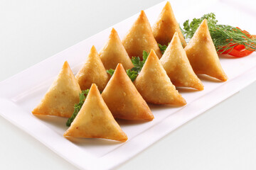 Wall Mural - Isolated Potato Samosa Snacks on White Background. Indian Ramadan Food, Pakistani Iftar Meal.