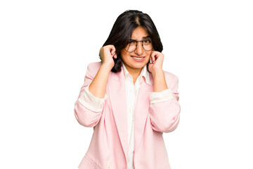 Wall Mural - Young Indian business woman wearing a pink suit isolated covering ears with hands.