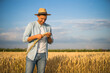 © inesbazdar - Happy farmer is standing in his growing wheat field and examining crops after successful sowing.