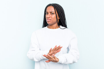 Wall Mural - Young African American woman with braids hair isolated on blue background doing a denial gesture