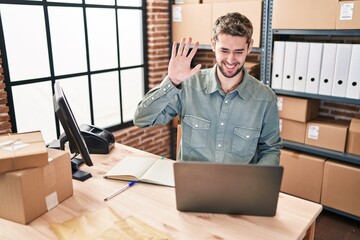 Wall Mural - Hispanic man with beard working at small business ecommerce looking positive and happy standing and smiling with a confident smile showing teeth