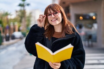 Sticker - Young woman smiling confident reading book at street