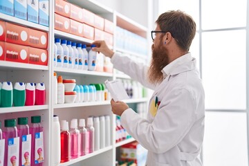 Sticker - Young redhead man pharmacist reading prescription at pharmacy