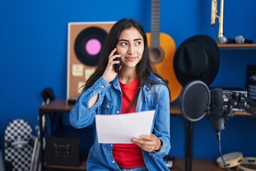 Poster - Young hispanic girl artist talking on the smartphone at music studio