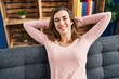 © Krakenimages.com - Young woman relaxed with hands on head sitting on sofa at home
