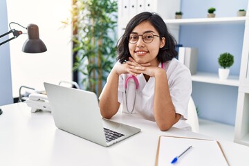 Canvas Print - Young latin woman wearing doctor uniform working at clinic