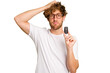 Young caucasian man holding car keys isolated on white background being shocked, she has remembered important meeting.