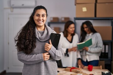 Poster - Three women working at small business ecommerce looking positive and happy standing and smiling with a confident smile showing teeth