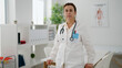 © Krakenimages.com - Middle age hispanic woman wearing doctor uniform standing with relaxed expression at clinic
