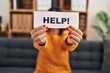 © Krakenimages.com - Young latin woman patient stressed holding help banner at clinic