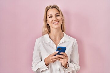 Sticker - Young caucasian woman using smartphone typing message smiling with a happy and cool smile on face. showing teeth.