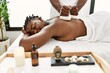 © Krakenimages.com - Young african american woman reciving herbal pouches thai massage at beauty center.