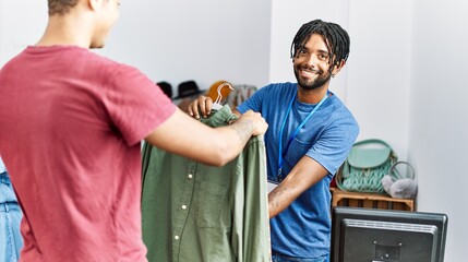 Wall Mural - Two men shopkeeper and customer choosing shirt at clothing store