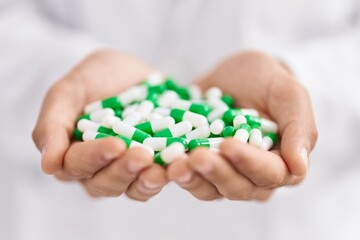 Poster - Young arab man pharmacist holding capsules at pharmacy