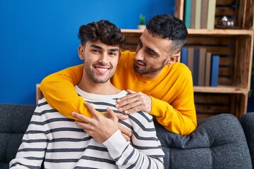 Sticker - Two man couple hugging each other sitting on sofa at home