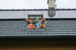 © Halfpoint - Happy family leaning out from skylight window in their new house with solar panels on the roof. Alternative energy, saving resources and sustainable lifestyle concept.