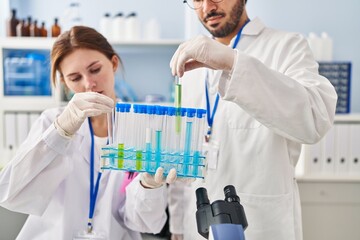 Sticker - Man and woman scientist partners holding test tubes at laboratory