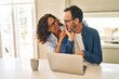 © Krakenimages.com - Middle age hispanic couple hugging each other using laptop at kitchen