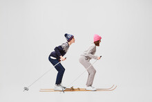 Winter Stroll. Two Funny Retro Skiers In Warm Winter Casual Wear Skiing Isolated On Grey Background. Retro, Vintage, Sport, Holidays, Hobbies Concept