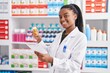 © Krakenimages.com - African american woman pharmacist reading prescription holding pills bottle at pharmacy