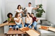 © Krakenimages.com - Group of young friends having party eating italian pizza and singing song at home.